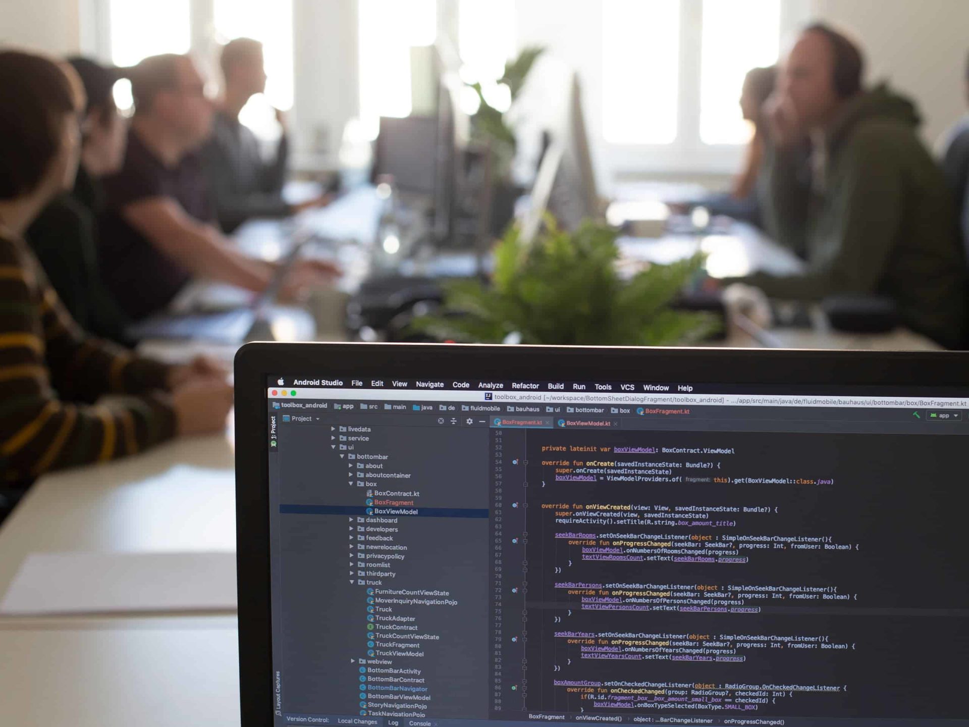 Meetingraum mit fluidmobile-Mitarbeitern verschwommen und im Vordergrund ein Bildschirm