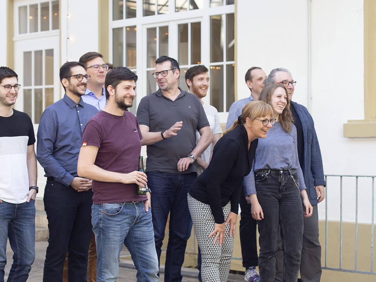 join us, Team der fluidmobile im Innenhof unserer Büroräume in Karlsruhe